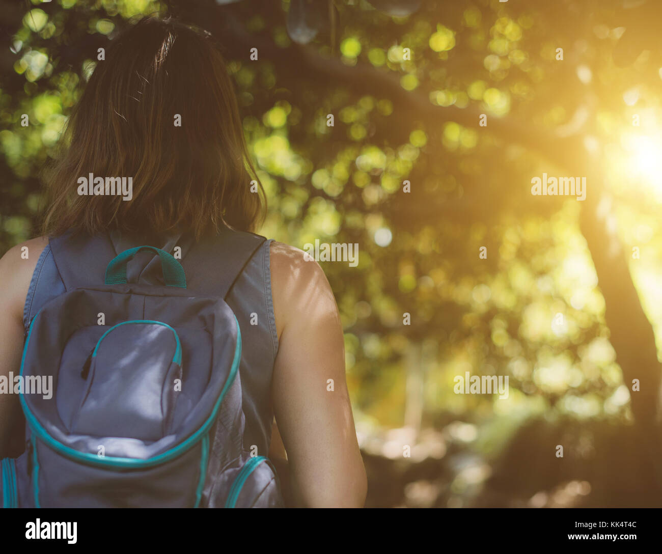 Woman with backpack in the forest. View from the back Stock Photo - Alamy