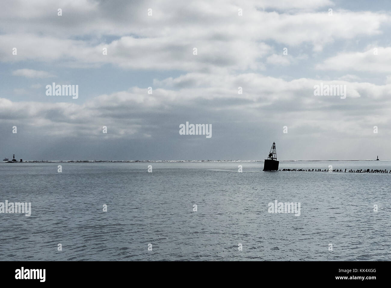 cold winter view of Lake Michigan, clouded sky, horizon over water with breakwater in distance Stock Photo