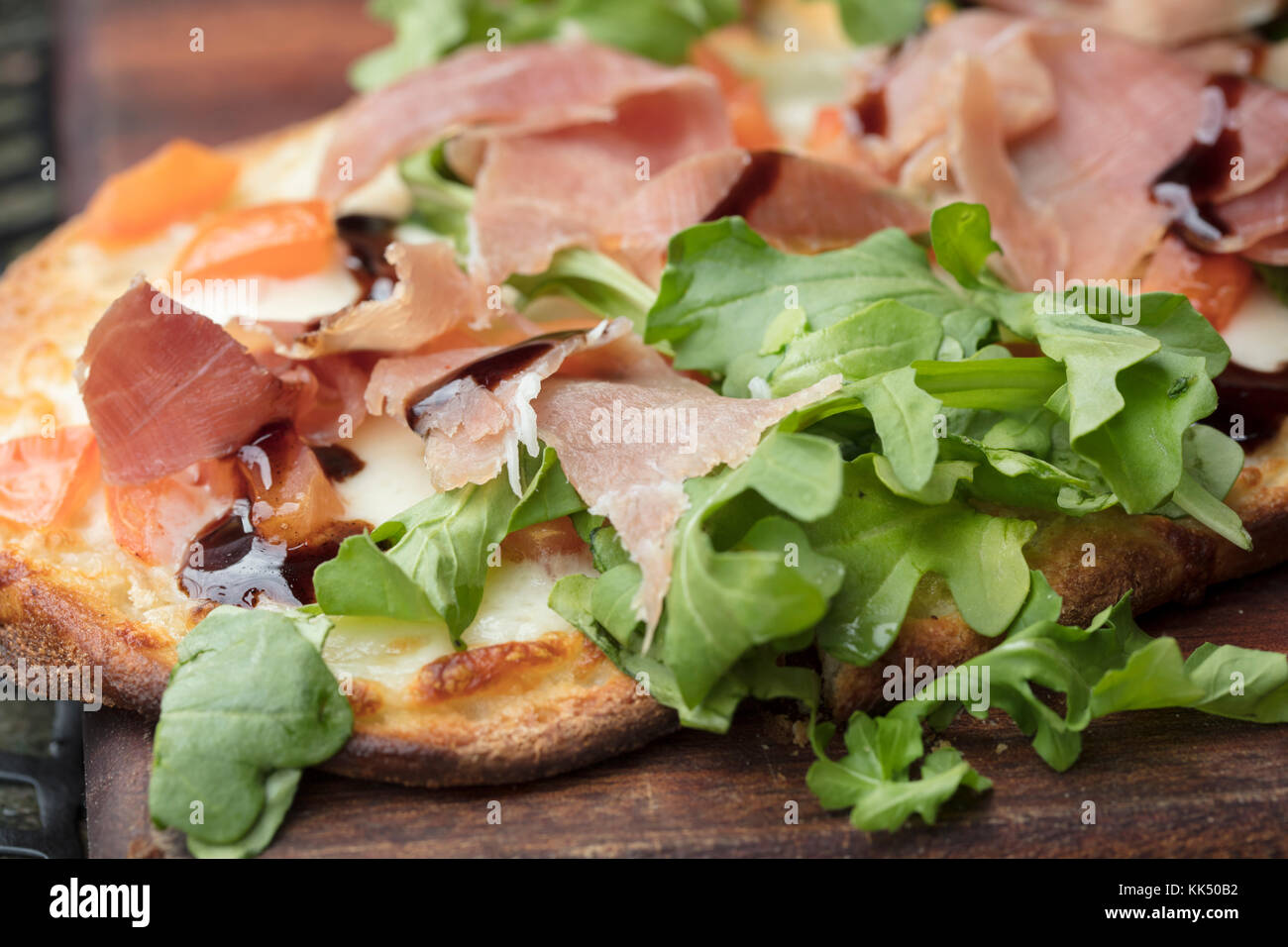 Prosciutto, arugula and cheese flatbread dish baked until crispy and