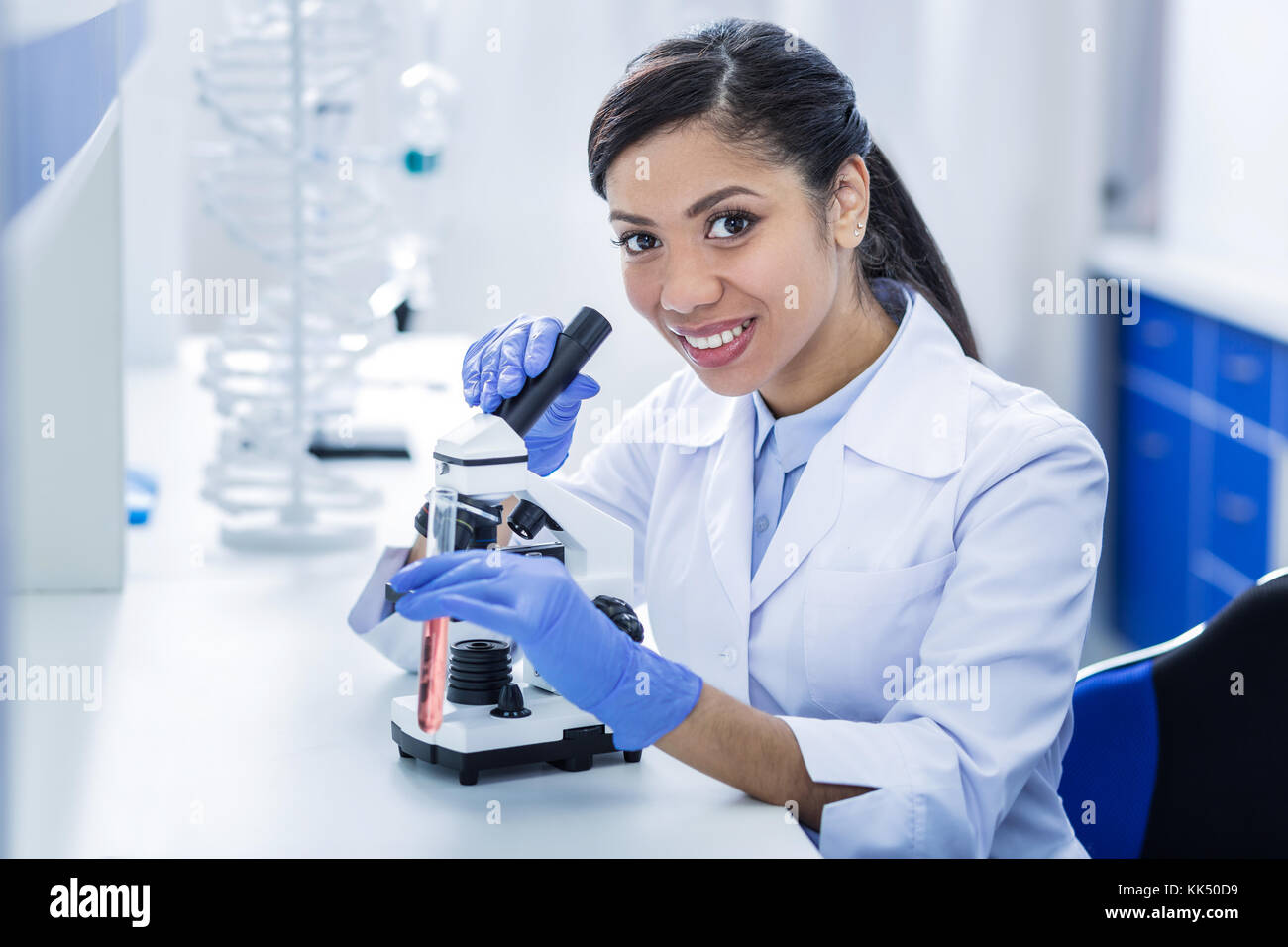 Delighted positive woman holding a microscope Stock Photo - Alamy