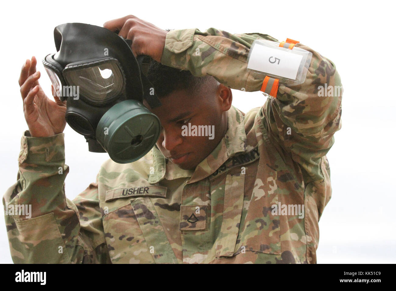 Pfc. Michael Usher dons a protective mask prior to entering a gas chamber Nov. 8 during the California Army National Guard's 2017-18 Best Warrior Competition at Camp San Luis Obispo, California. This was one of the last tests after four competitive days to find California’s Best of the Best. (Army National Guard photo by Staff Sgt. Eddie Siguenza) Stock Photo