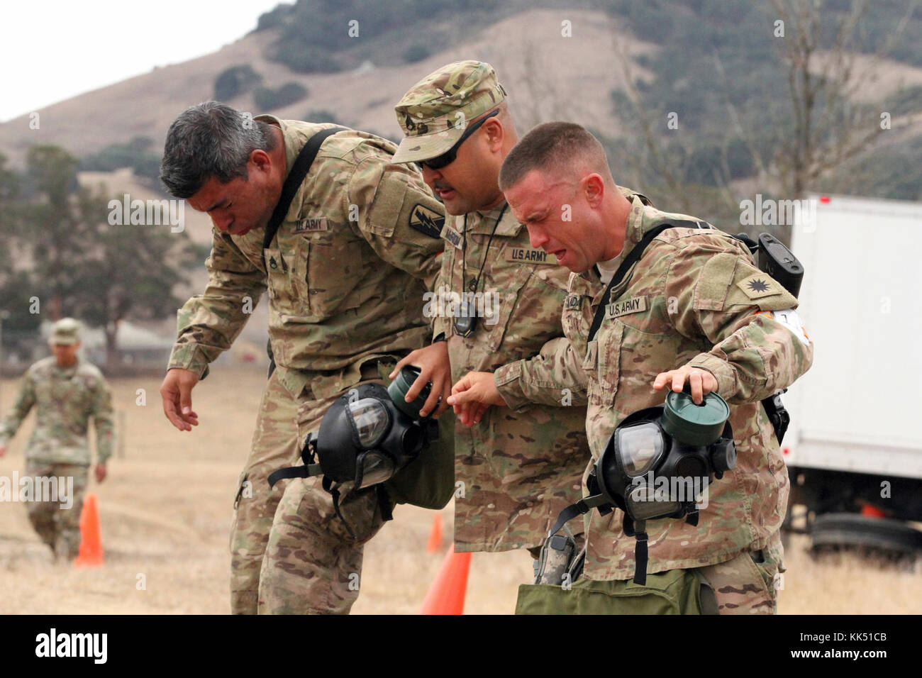 Staff Sgt. Francisco Vianaescobar, left, and Sgt. Joshua Monday, competitors in the California Army National Guard's 2017-18 Best Warrior Competition, get needed assistance from cadre Staff Sgt. James McBroom after exiting a gas chamber Nov. 8 during one of the final tests to find the Cal Guard’s Best of the Best. (Army National Guard photo by Staff Sgt. Eddie Siguenza) Stock Photo