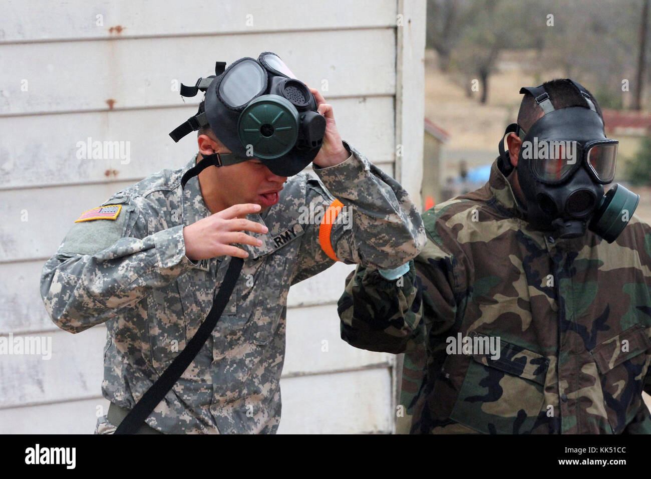 Spc. Fabio Avetisyan, left, coughs and gasps for air Nov. 8 after exiting a gas chamber during the California Army National Guard's 2017-18 Best Warrior Competition at Camp San Luis Obispo, California. This was one of the last tests after four competitive days to find California’s Best of the Best. (Army National Guard photo by Staff Sgt. Eddie Siguenza) Stock Photo