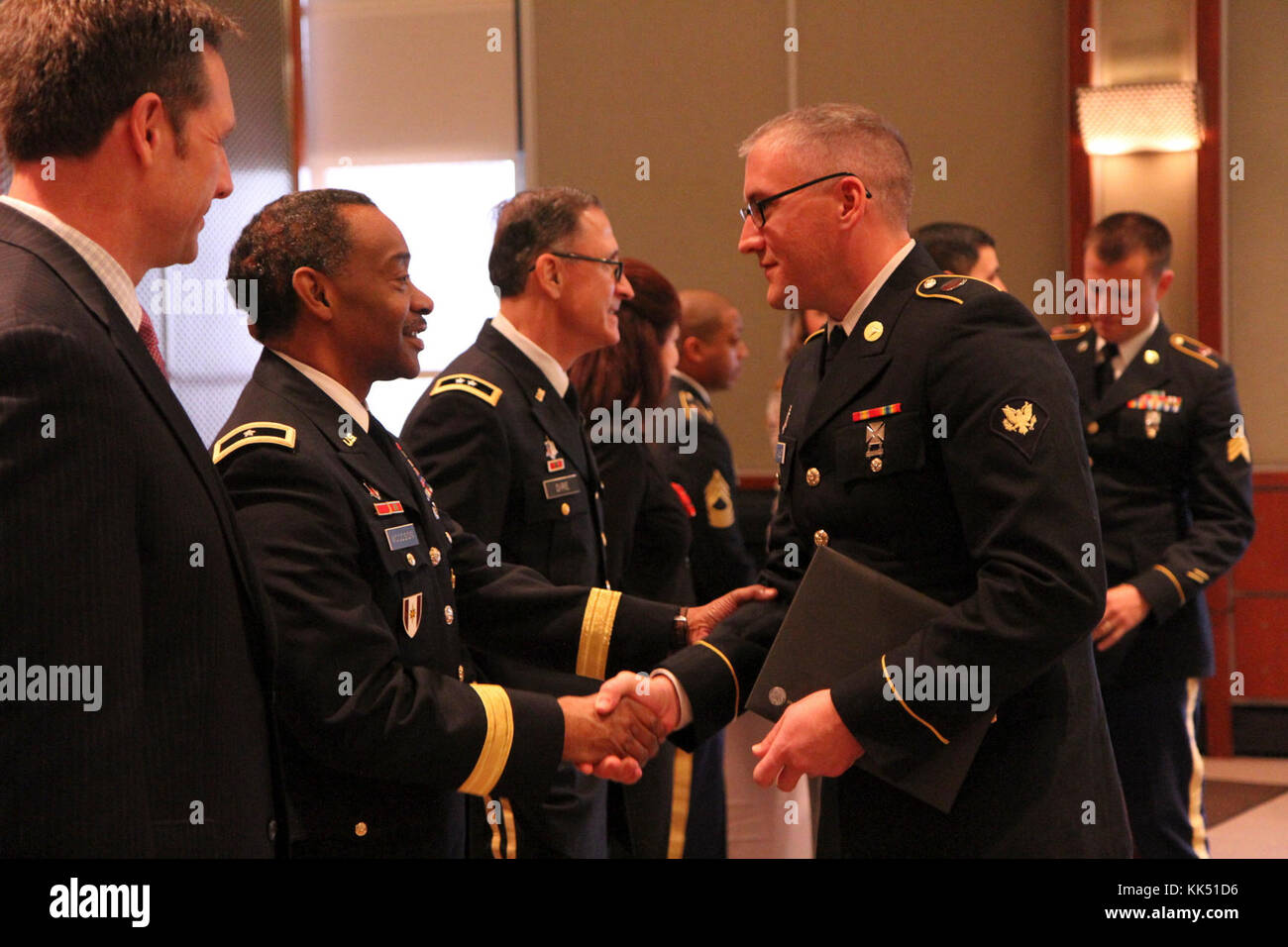 3d MCDS Deputy Commanding General Brig. Gen. Jonathan Woodson (second from the left), along with guest speaker, CEO of Numotion Mike Swinford (far left), 807th MCDS Commanding General Maj. Gen. Daniel Dire (center), and representatives from General Electric Healthcare congratulate the graduating class.  Brig. Gen. Woodson shakes one of the graduates hands, Spc. Greg Malihot (right) from the 327th Medical Logistics Company in Newport, R.I.  This graduation marks the 100th Army Reserve soldier to graduate from the externship.  The externship for biomedical equipment specialists with the 68A mili Stock Photo