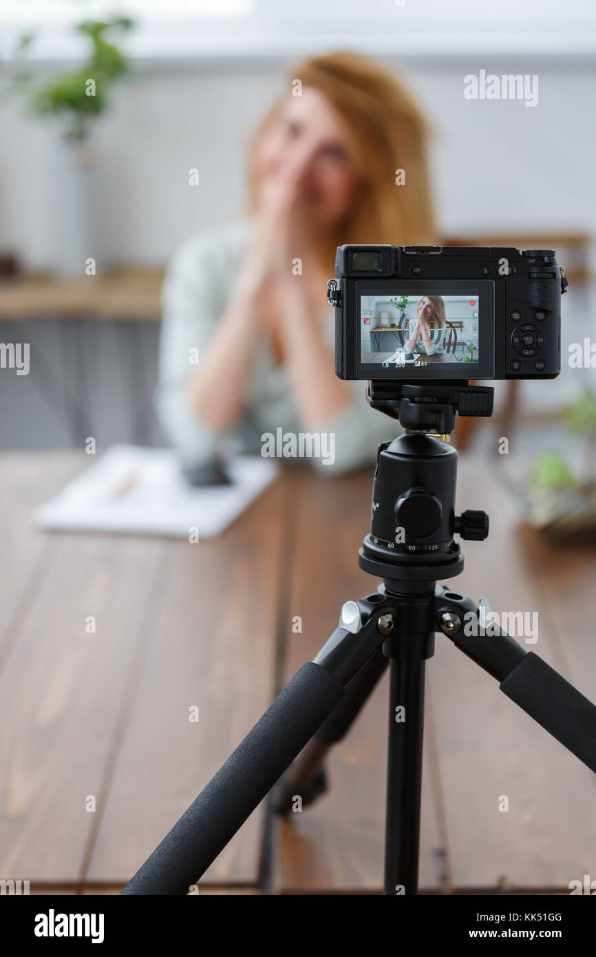 Blurred image of woman blogger sitting on table with succulent in glass jar. Stock Photo