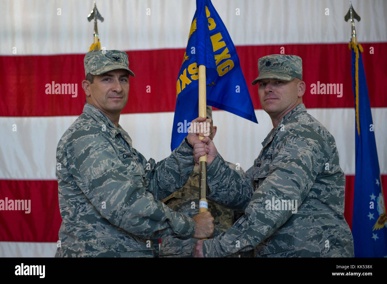 Col. John Chastain III, 23d Maintenance Group commander, left, presents Lt. Col. Neal Van Houten, 23d Maintenance Squadron commander, with the 23d MXS guidon during a re-designation ceremony, Nov. 9, 2017, at Moody Air Force Base, Ga. Van Houten took command of Air Combat Command’s second largest squadron, leading the 800 men and women who are responsible for executing safe and reliable maintenance on aircraft systems, ground equipment and munitions to support the 23d Wing's attack and rescue missions. (U.S. Air Force photo by Senior Airman Greg Nash) Stock Photo