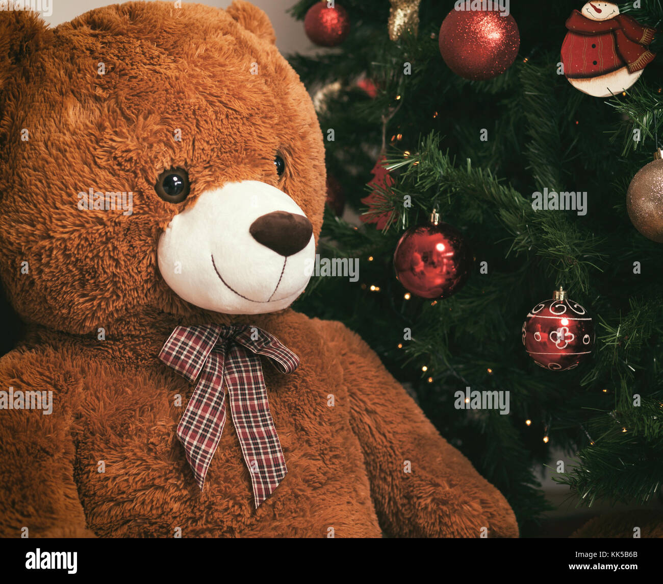 Teddy bear near christmas tree with gifts. Stock Photo