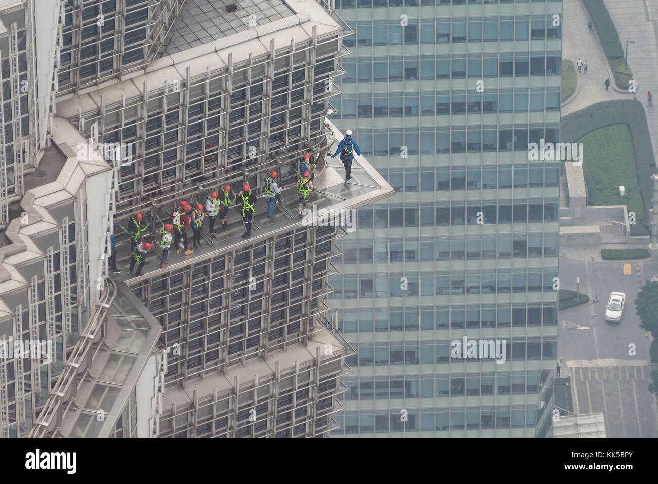 People walking outside a skycraper in Shanghai Stock Photo