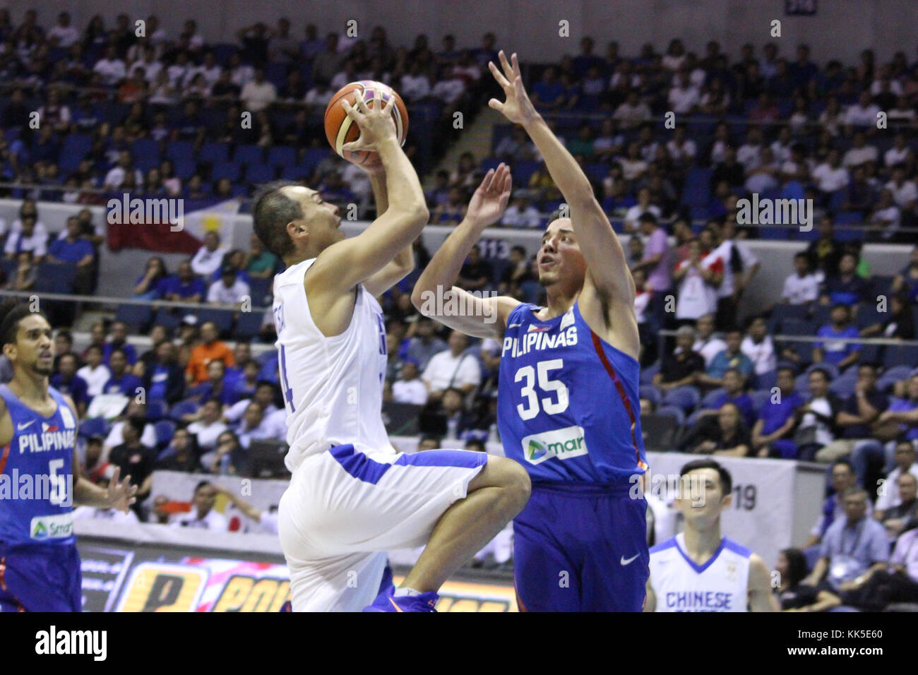 Quezon City, Philippines. 27th Nov, 2017. Wen-Chen Tsai (14) of Chinese Taipei tries to shoot the ball over Matthew Wright (35) of the Philippines during their FIBA World Cup Qualifying Game. Gilas Pilipinas defeated the visiting Chinese Taipei team 90-83 to complete a sweep of their first two assignments in the FIBA 2019 World Cup qualifiers. Credit: Dennis Jerome Acosta/ Pacific Press/Alamy Live News Stock Photo