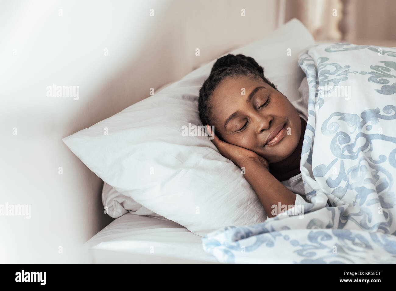 Young African woman fast asleep in her bed at home Stock Photo