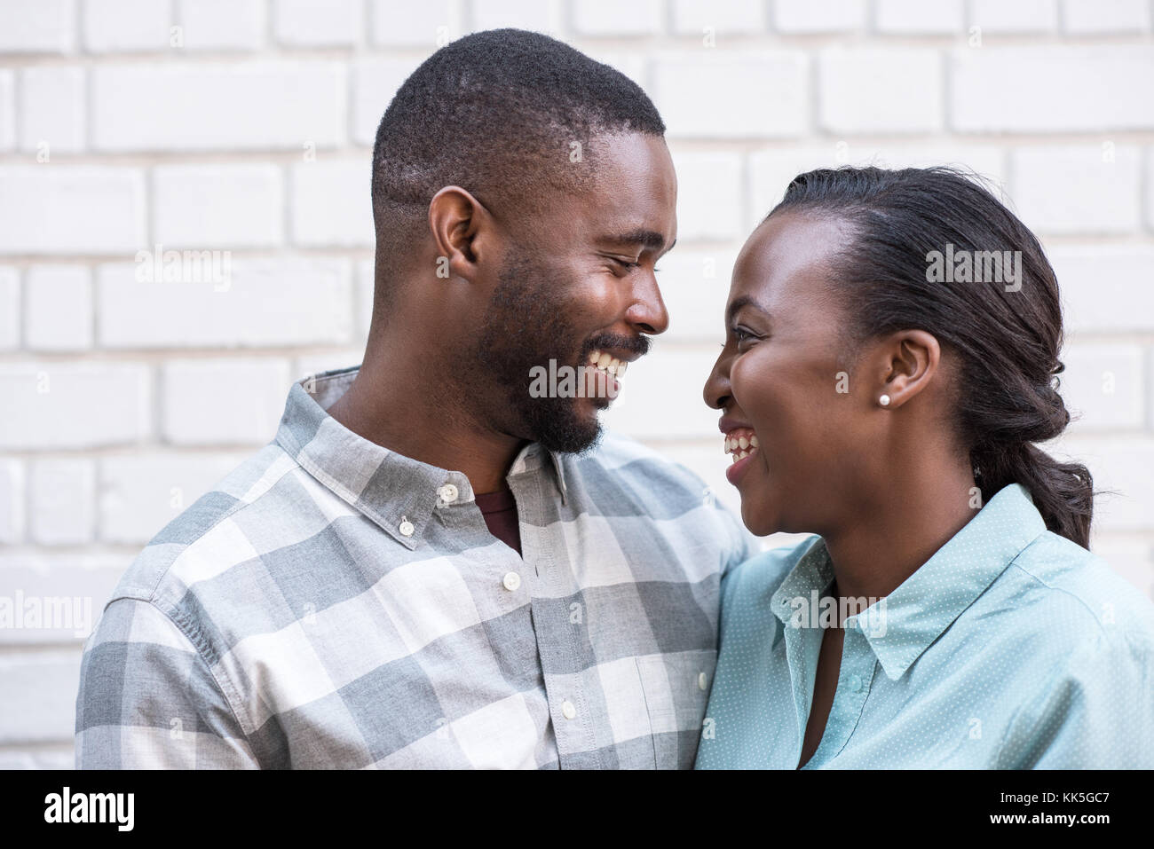 Content African couple smiling at each other in the city Stock Photo