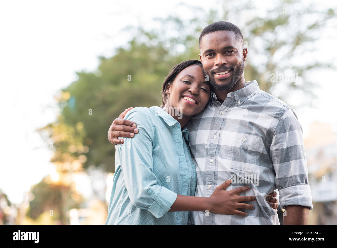 African couple holding each other outside on a sunny day Stock Photo
