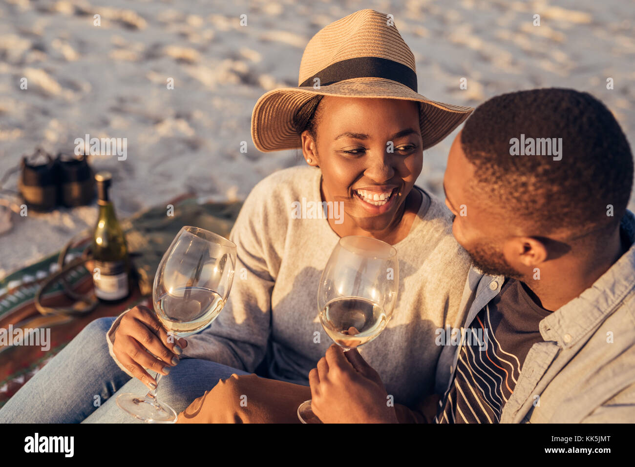 Happy young African couple drinking wine together at the beach Stock ...