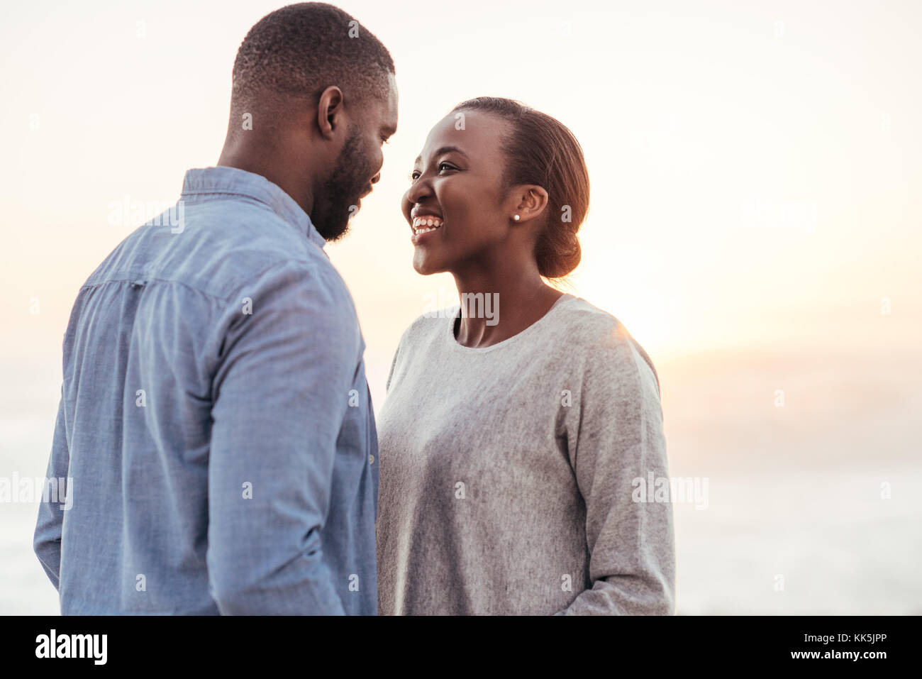 Smiling young African couple talking together at the beach Stock Photo ...
