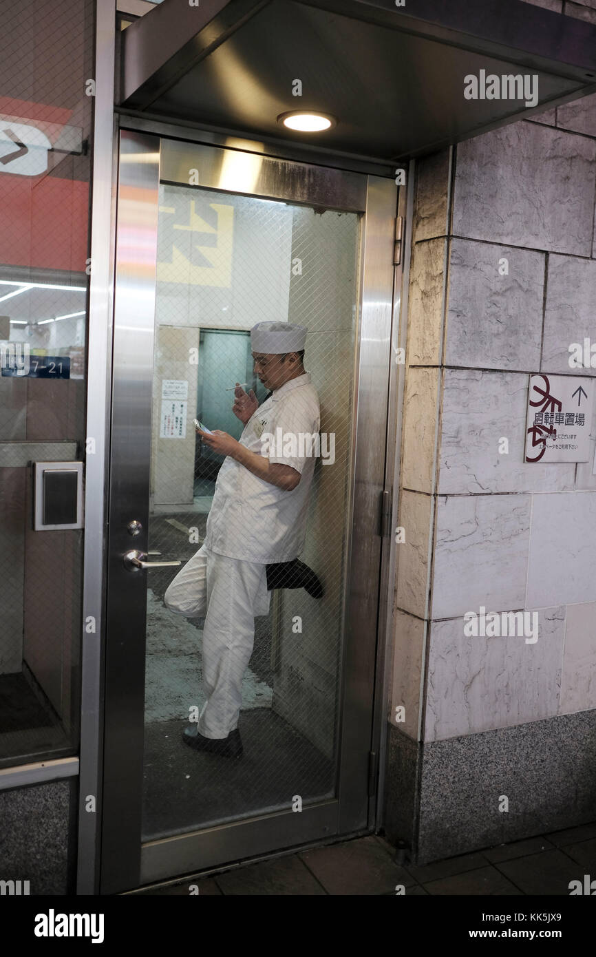 Worker taking a break and smoking at a street in Osaka, Japan. Stock Photo