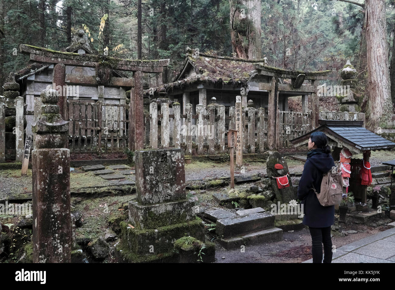 a girl stand next a tomb at Okunoin cemetery. Koyasan, Japan. Stock Photo