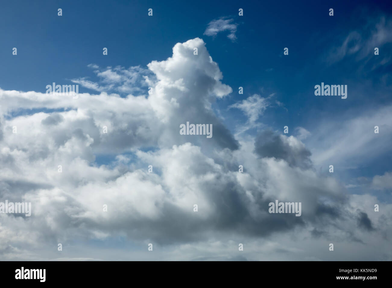 Dramatic clouds in sunlight against blue sky. Stock Photo