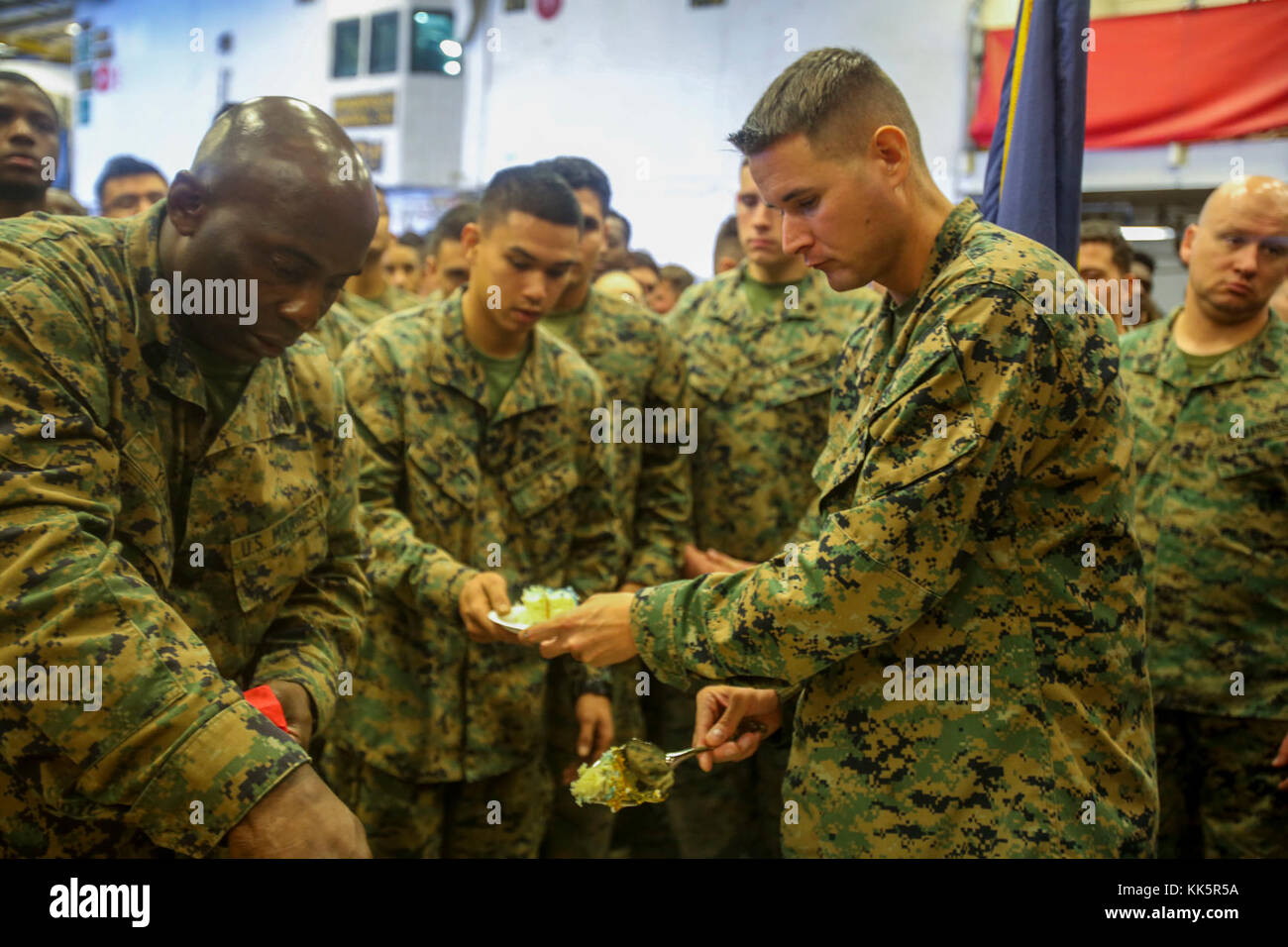 Sgt. Maj Jeffrey A. Young, 26th MEU Sergeant Major, and Sgt. Major Christopher Cary, 2nd Battalion 6th Marine Regiment Sergeant Major cut and hand out cake to Marines during a cake cutting ceremony aboard the amphibious assault ship Iwo Jima (LHD 7), celebrating the Marine Corp’s 242nd Birthday, Nov. 10, 2017. The Marines and Sailors celebrated the birthday with a cake cutting ceremony while conducting Combined Composite Training Unit Exercise (COMPTUEX) in the Atlantic Ocean. (U.S. Marine Corps photo by Cpl. Jon Sosner) Stock Photo