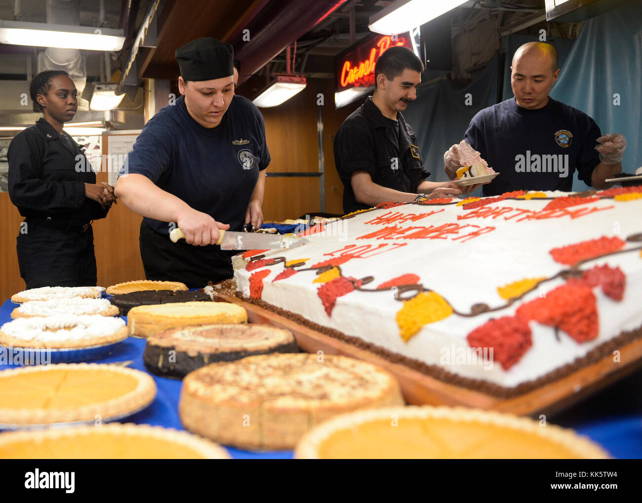 PACIFIC OCEAN (Nov. 22, 2017) U.S. Navy Sailors serve cake during a special birthday month dinner aboard the aircraft carrier USS Nimitz (CVN 68), Nov. 22, 2017, in the Pacific Ocean. The Nimitz Carrier Strike Group is on a regularly scheduled deployment to the Western Pacific. The U.S. Navy has patrolled the Indo-Asia-Pacific region routinely for more than 70 years promoting peace and security. (U.S. Navy photo by Mass Communication Specialist Seaman Jose Madrigal) Stock Photo