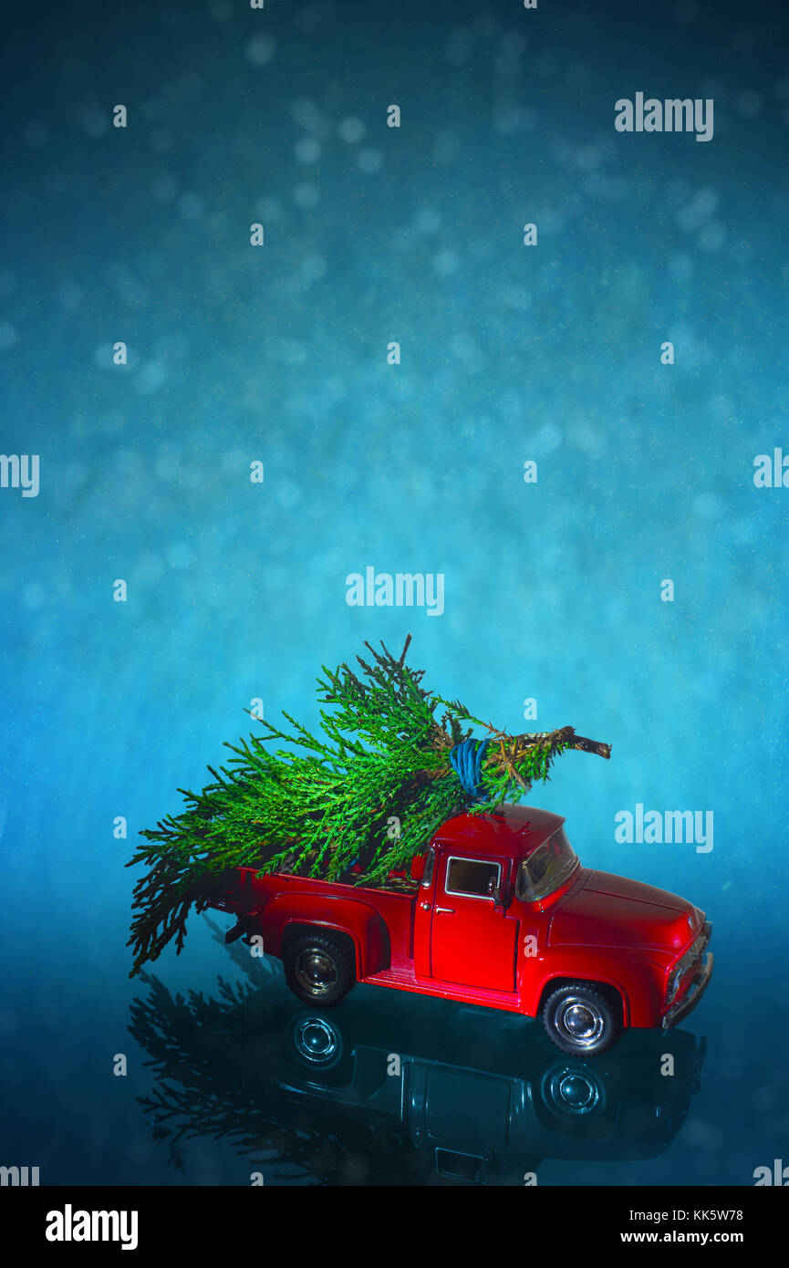 Red miniature vintage truck deliver Christmas tree on its back on a blue snow illustration background Stock Photo