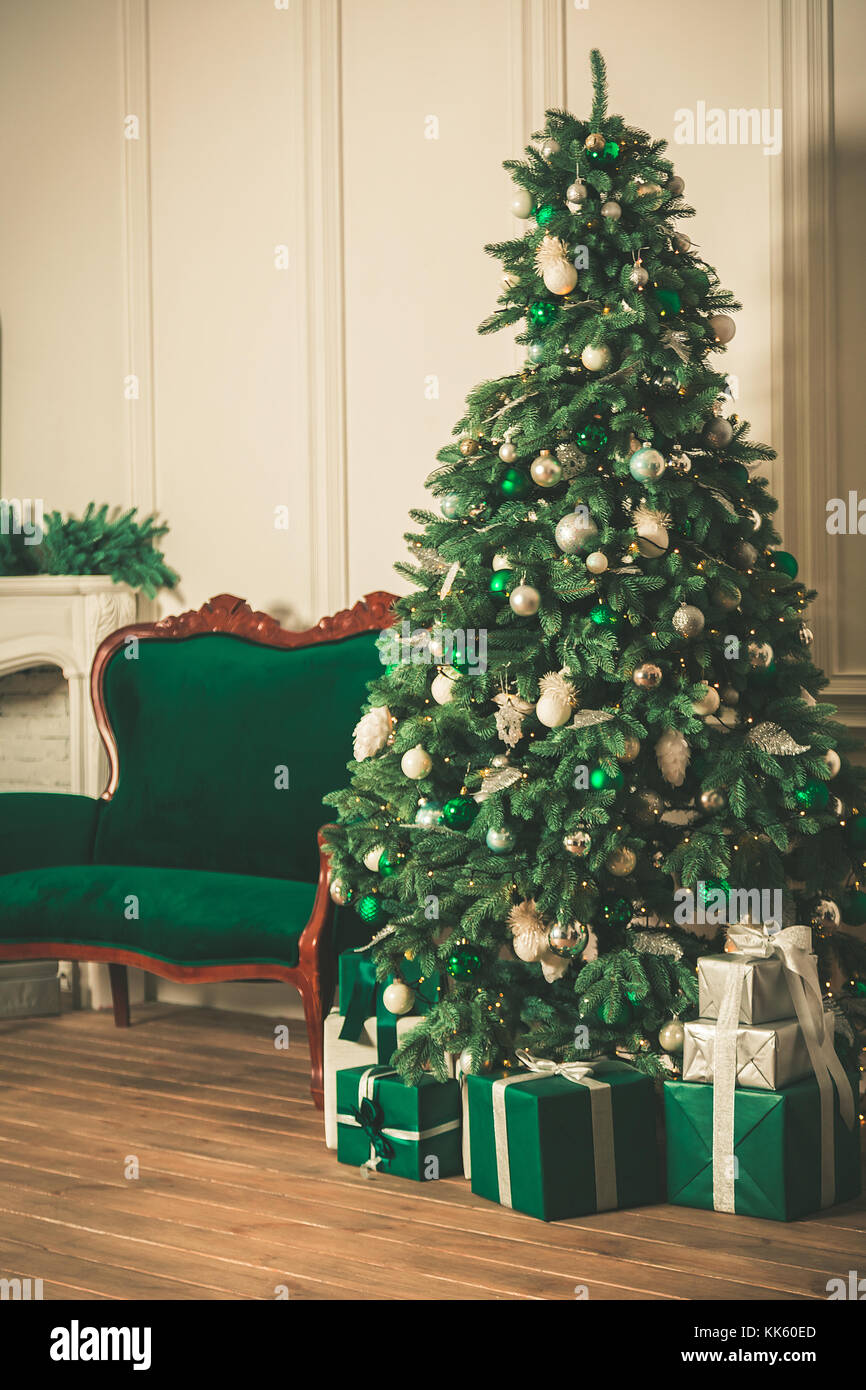 Christmas living room with a fireplace, sofa, Christmas tree and gifts