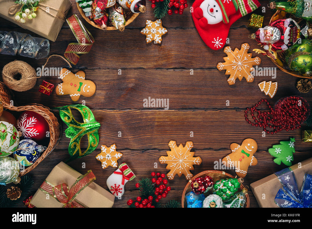 Christmas  background with gingerbread, decorations and gift boxes, balls, toy on vintage old wooden board. Beautiful xmas frame. Idea for advertising Stock Photo