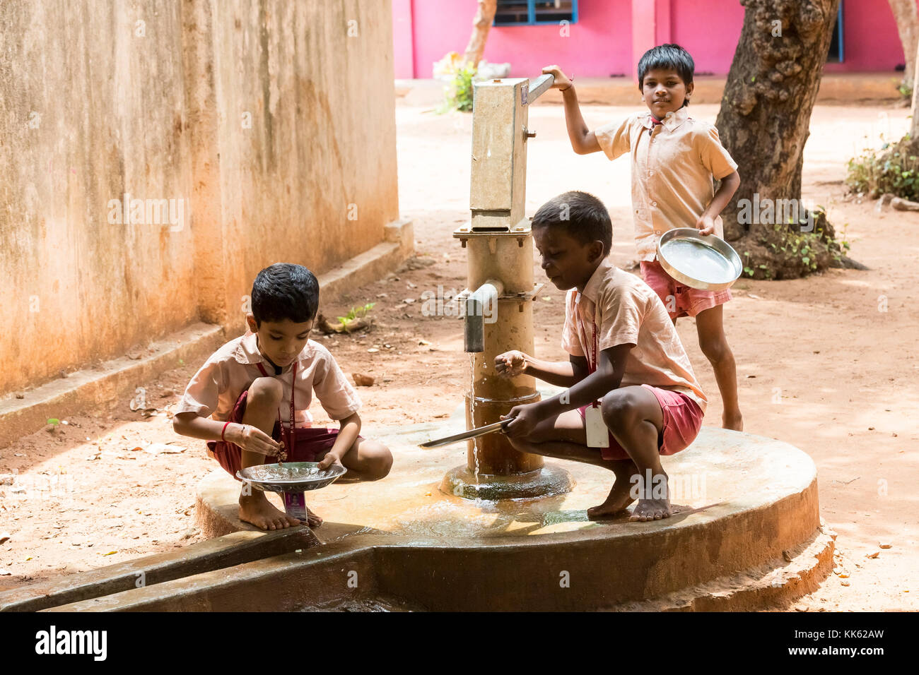 PONDICHERY, PUDUCHERY, INDIA - SEPTEMBER 04, 2017. Unidentified boys girls children clean their plates after lunch at the outdoor canteen. Stock Photo