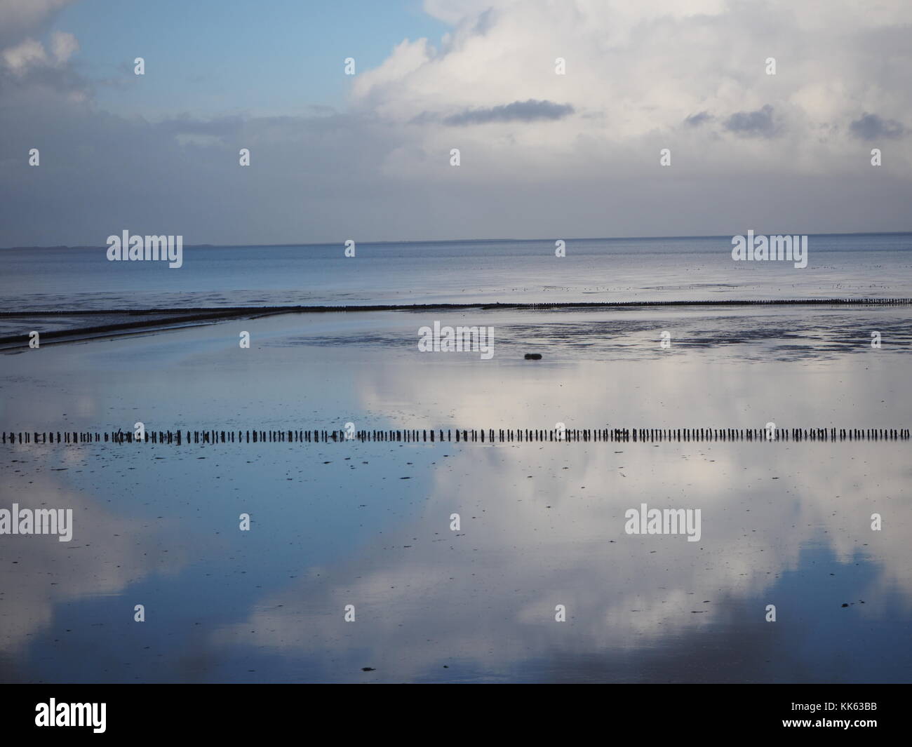 Reflection of clouds and sky in the wadden sea of the atlantic ocean Stock Photo