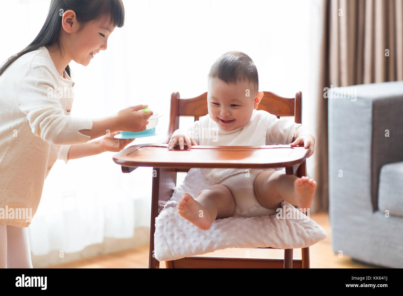 Little Chinese girl feeding baby Stock Photo