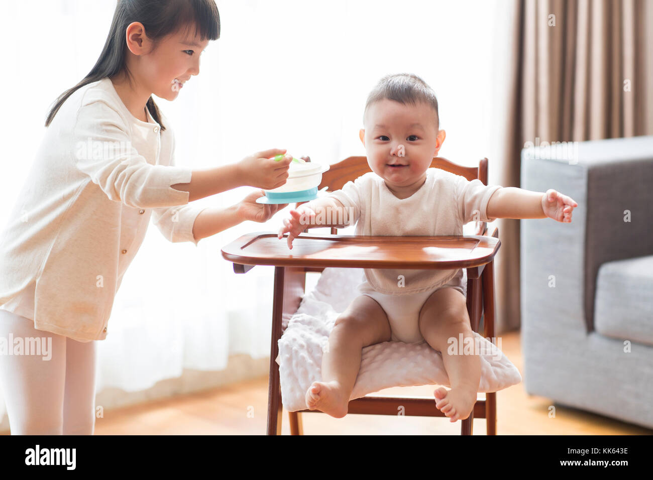 Little Chinese girl feeding baby Stock Photo