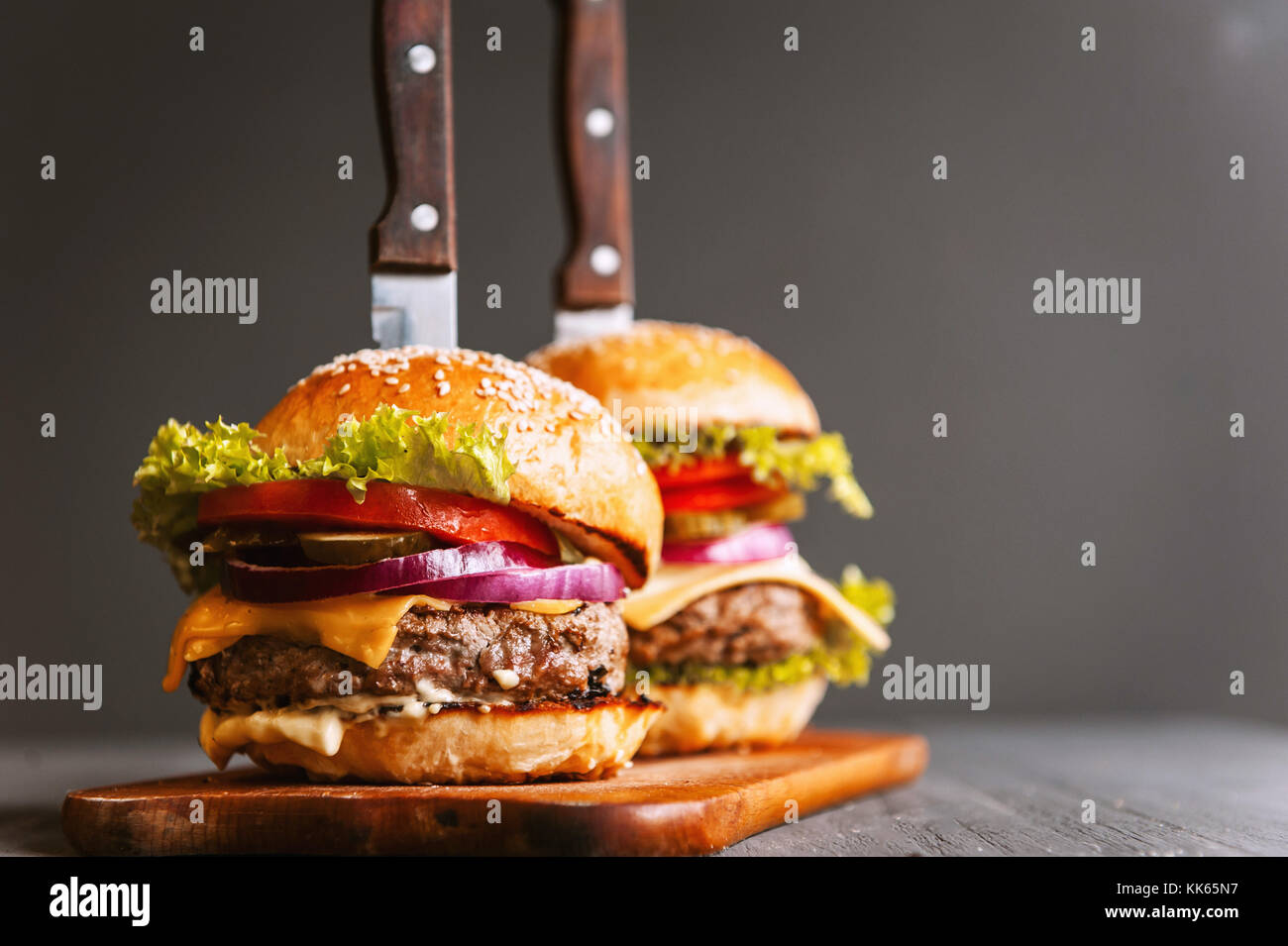 Two mouthwatering, delicious homemade burger used to chop beef. on the wooden table. The