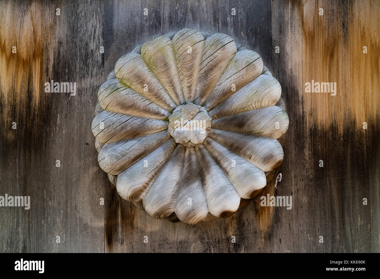 Nagano - Japan, June 3, 2017: Ancient wooden and weathered door with a carved Chrysanthemum at the Zenkoji temple Stock Photo