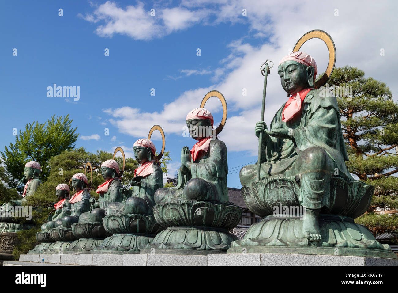 Nagano - Japan, June 3, 2017: Six bronze Buddha statues with red bibs and bonnets called rokujizo, or 6 jizo, at Zenkoji Temple, Nagano Stock Photo