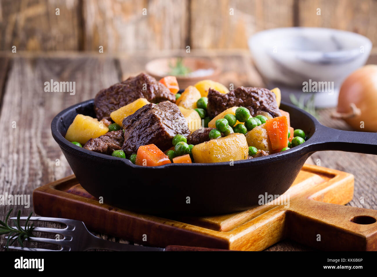 Beef and vegetable stew with potatoes in cast iron skillet on rural