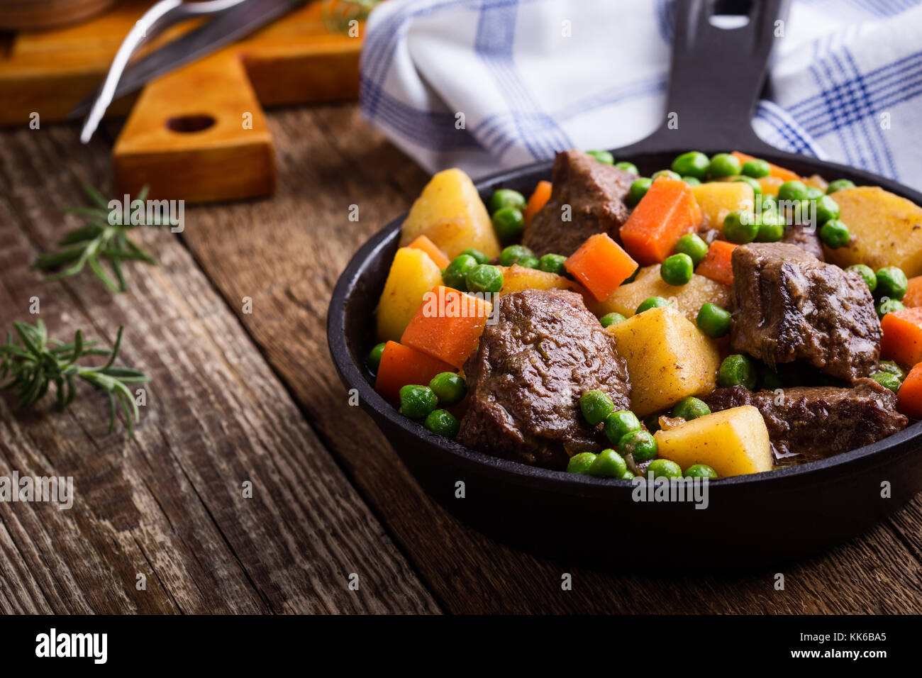 Beef and vegetable stew with potatoes in cast iron skillet on rural