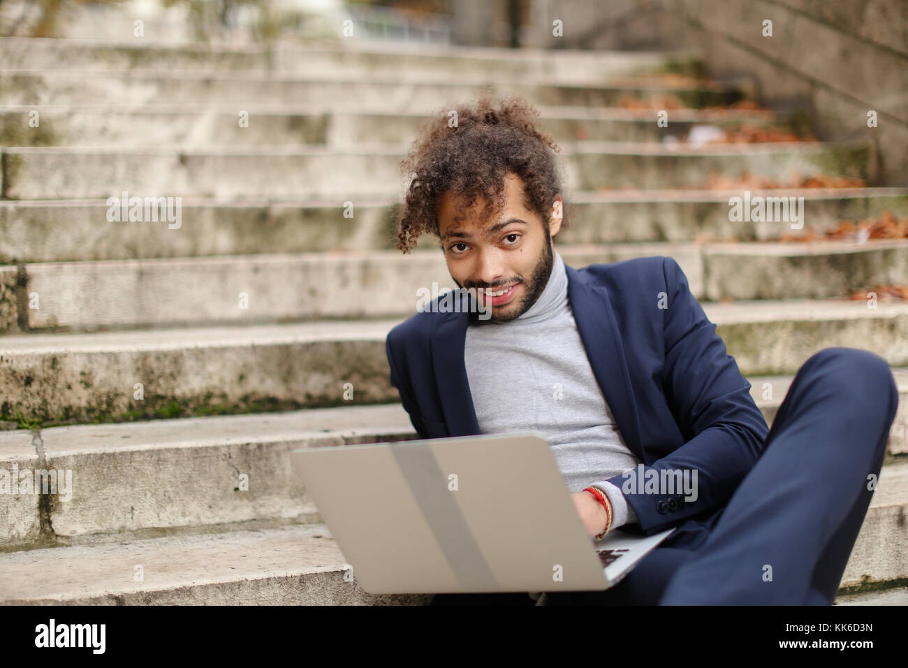 Personnel consultant chatting with client by laptop on steps. Stock Photo