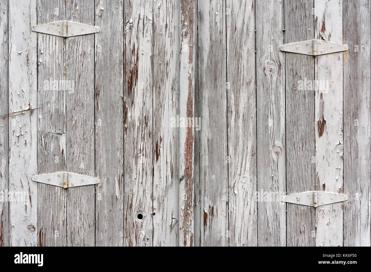 Weathered Old Wooden Garage Door With Grey Peeling Paint And Metal