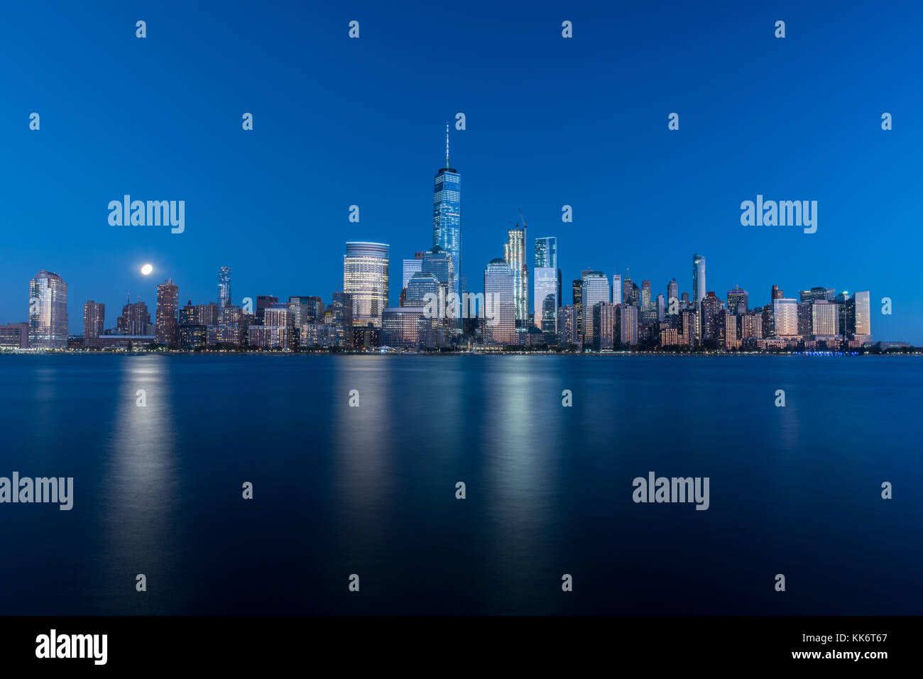 New York skyline as viewed across the Hudson River in New Jersey at dusk with the super moon in the background. Stock Photo