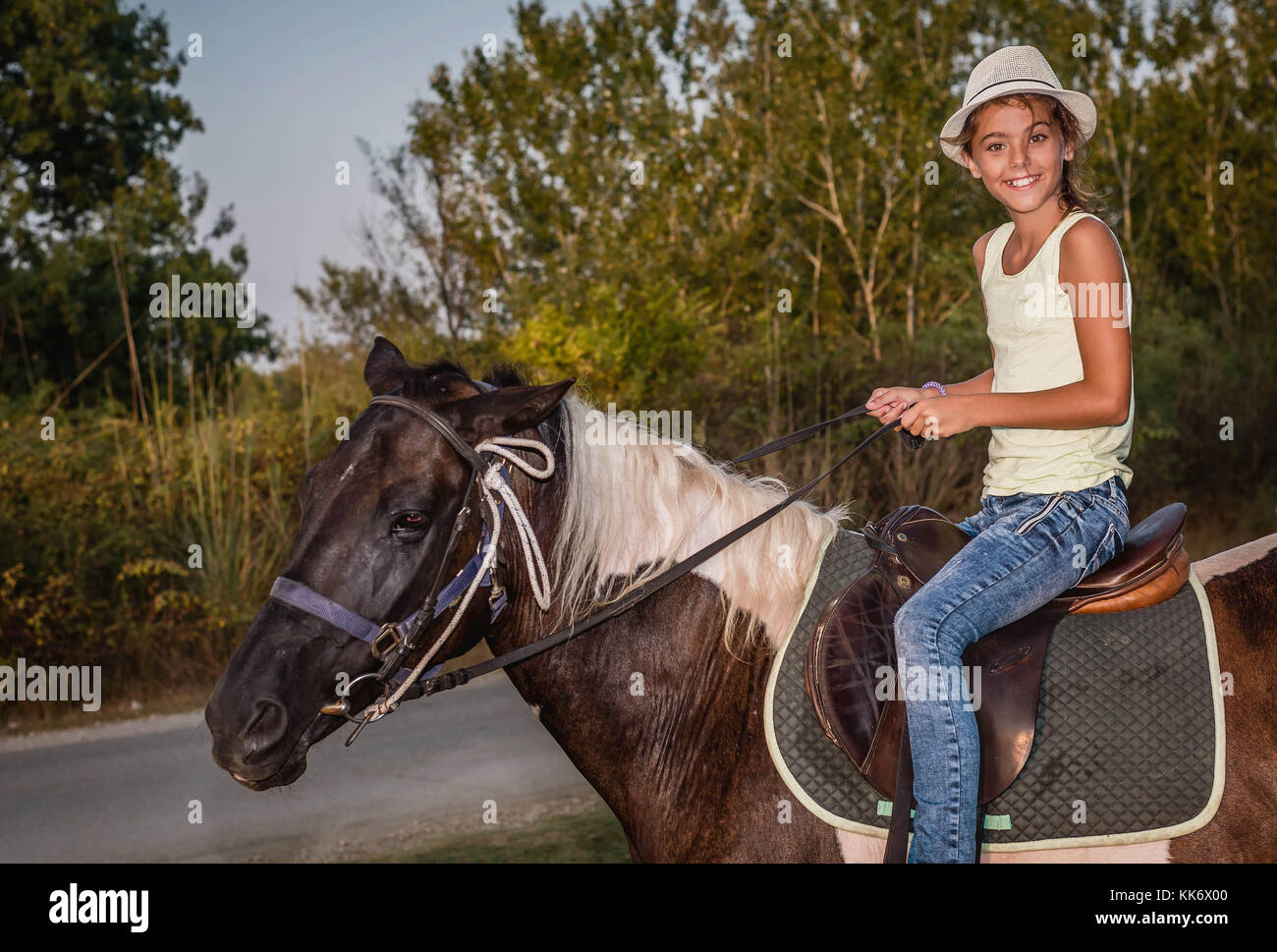 Girl with a hat riding a horse Stock Photo Alamy