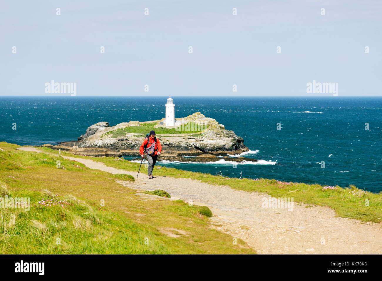 Walker on the South West Coast Path at Godrevy Head and lighthouse. North tip of St. Ives Bay, Cornwall, England, UK Stock Photo