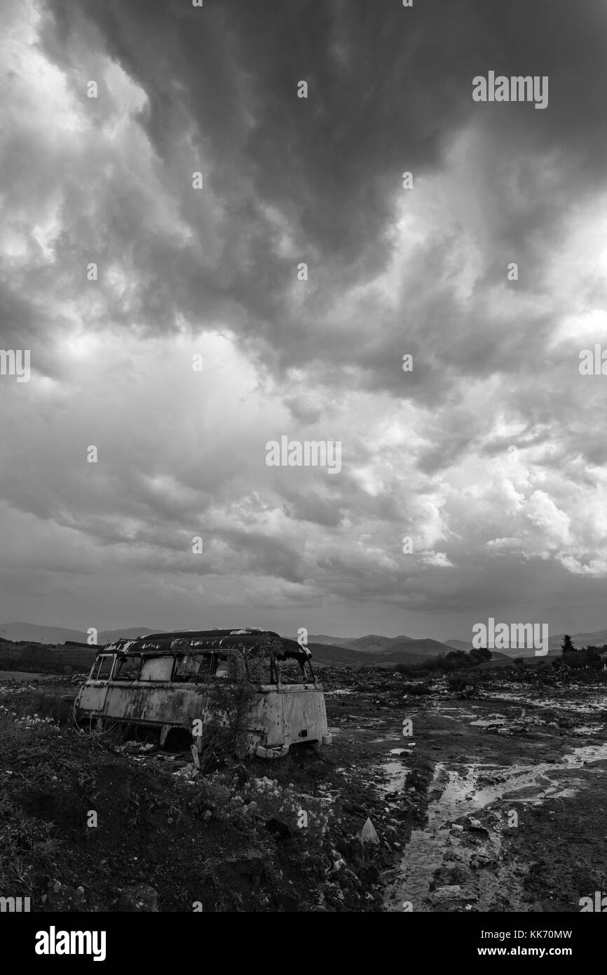 Old abandoned bus wreck in black and white contrast sky Stock Photo