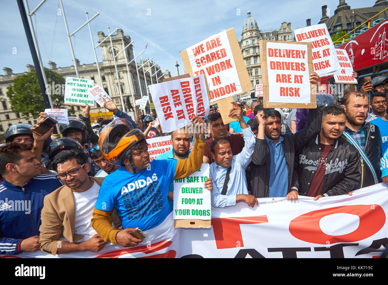 Moped riders, including couriers and delivery drivers, protest in Parliament Square in London against a recent spate of acid attacks Stock Photo