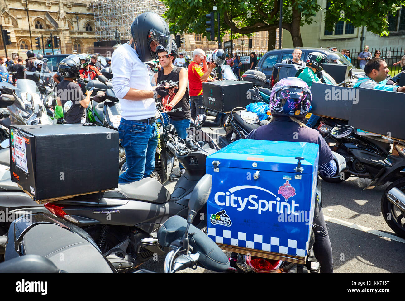Moped riders, including couriers and delivery drivers, protest in Parliament Square in London against a recent spate of acid attacks Stock Photo