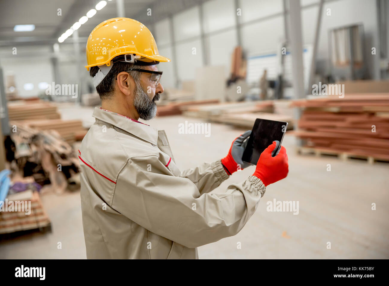Hand Some Engineering Handosme engineer with helmet controlling works in factory with digital ...