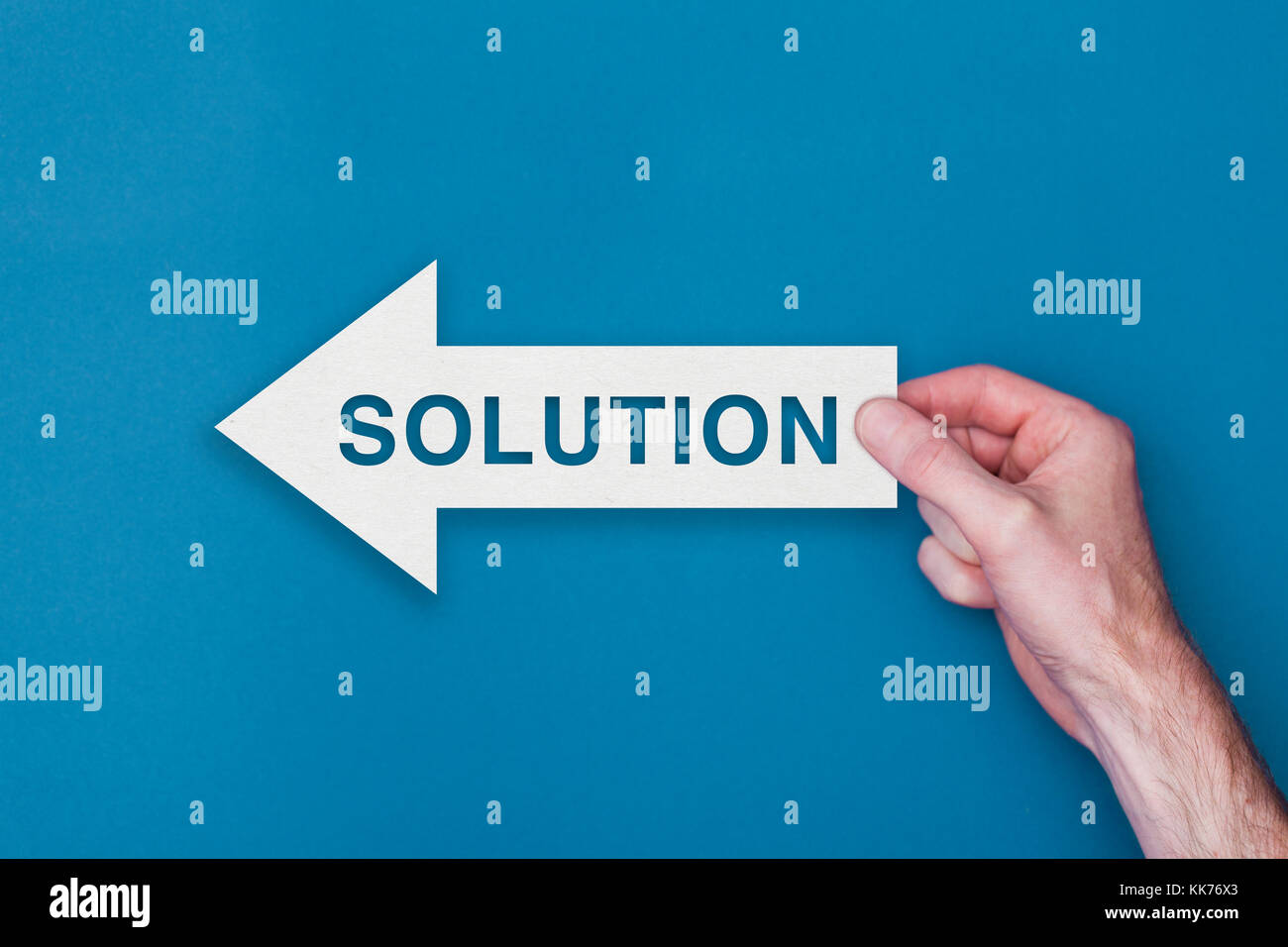Solution arrow direction held on a blue background Stock Photo Alamy