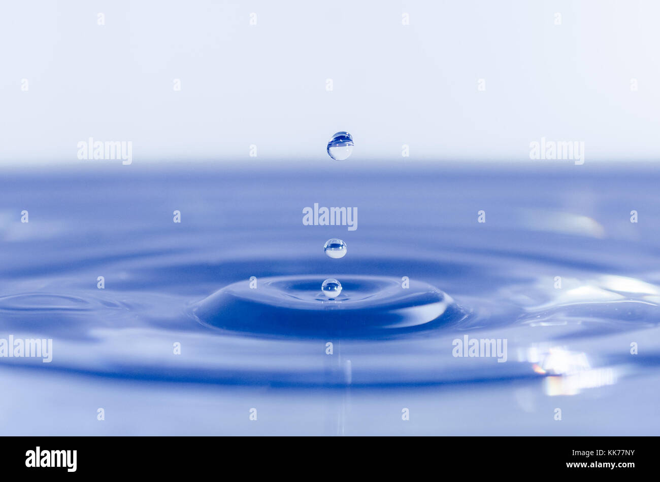 Close up of water drops dropping into water Stock Photo - Alamy