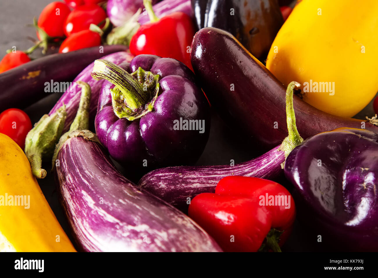 Small eggplant, yellow zucchini, tomatoes and purple pepper. Dark