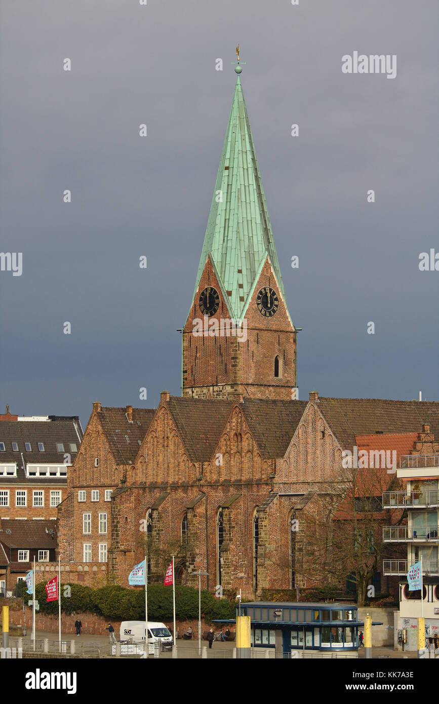 Bremen, Germany - November 23rd, 2017 - Historic St. Martin's church with tall spire and rain clouds in the background Stock Photo