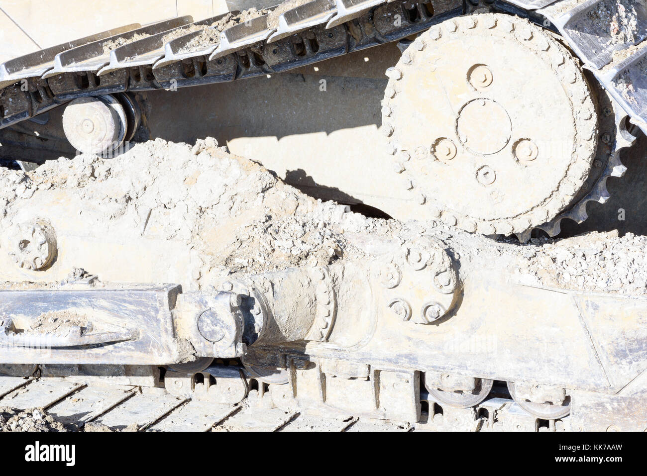 Mud clay encrusted earth moving tracks of a digger excavator machine in color with copy space area for gravel aggregate based ideas and designs Stock Photo