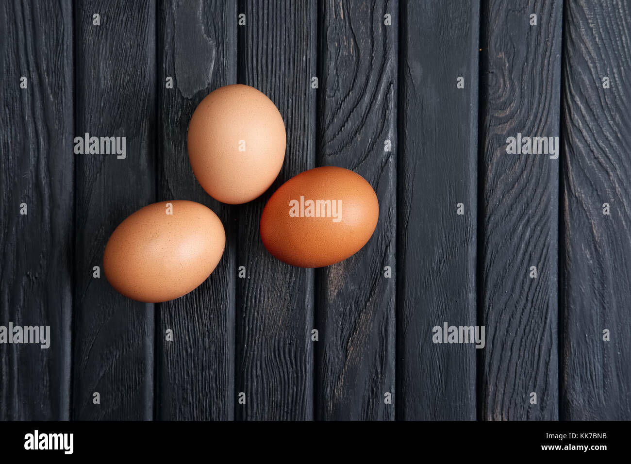 Top view of tree brown chicken eggs on wooden table Stock Photo - Alamy